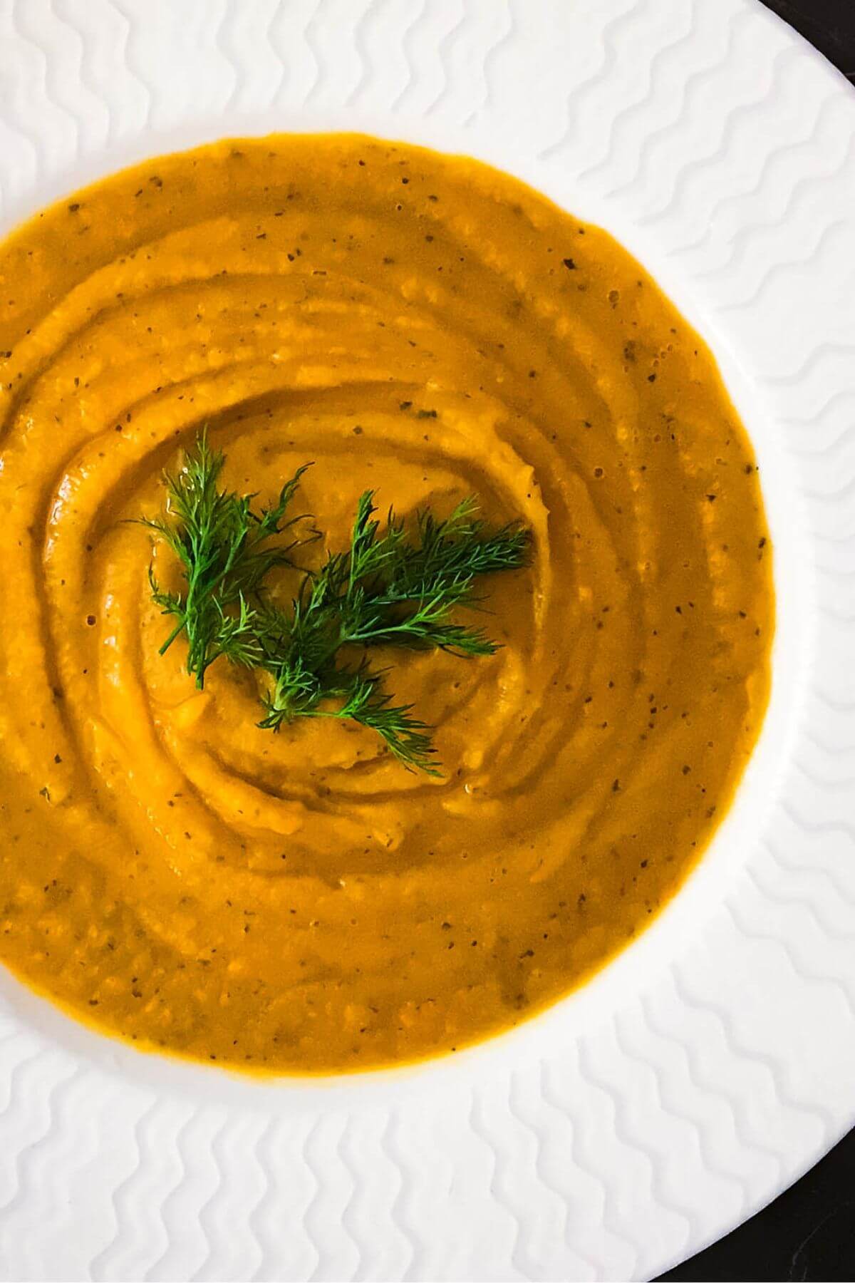 Bowl of Simple Yellow Cream Soup with herb garnish